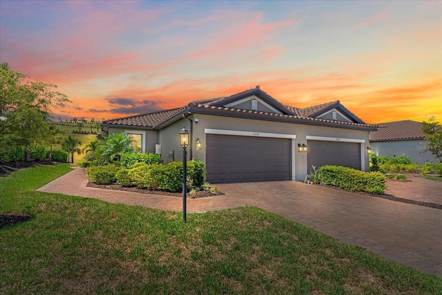 6250 Grandview Hill Ct, Bradenton, FL 34203 - view of front facade with a garage, stucco siding, driveway, a lawn, and a tile roof