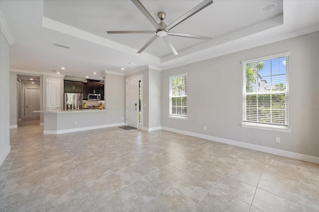 6250 Grandview Hill Ct, Bradenton, FL 34203 - unfurnished living room featuring a raised ceiling, plenty of natural light, ceiling fan, baseboards, and ornamental molding