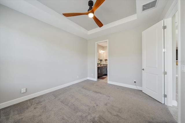 6250 Grandview Hill Ct, Bradenton, FL 34203 - unfurnished bedroom with carpet, baseboards, a raised ceiling, ensuite bathroom, and ceiling fan