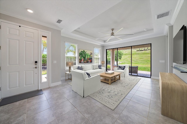 6250 Grandview Hill Ct, Bradenton, FL 34203 - living room featuring a ceiling fan, baseboards, a raised ceiling, light tile patterned flooring, and crown molding