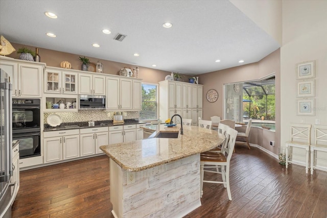 6907 47th Ct E, Ellenton, FL 34222 - kitchen with stainless steel microwave, a sink, plenty of natural light, a breakfast bar area, and recessed lighting