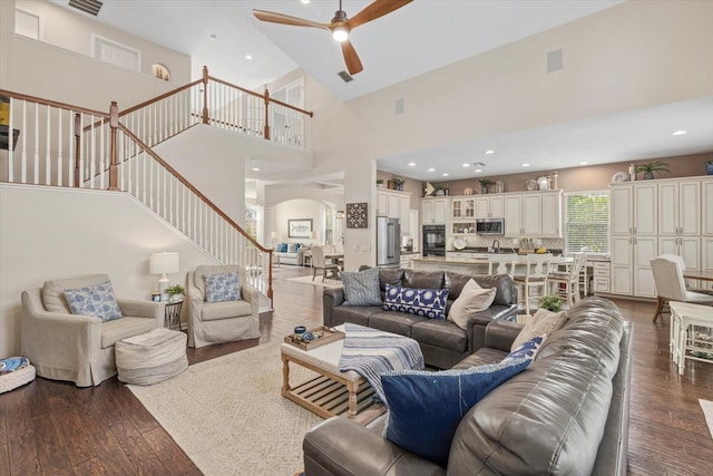 6907 47th Ct E, Ellenton, FL 34222 - living room with high vaulted ceiling, stairway, ceiling fan, arched walkways, and dark wood-style flooring