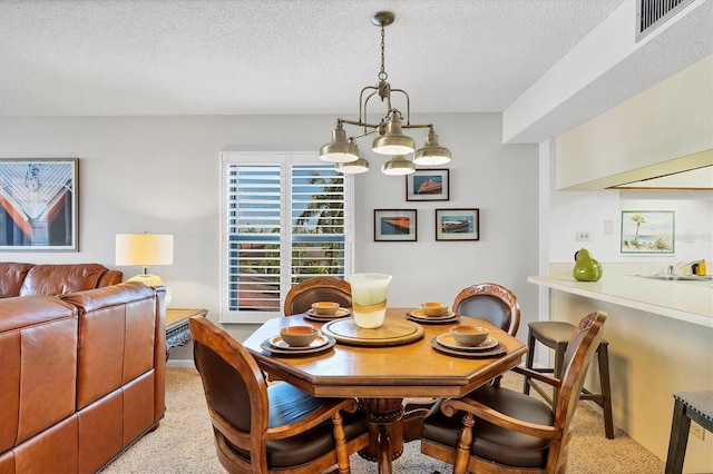 6480 Midnight Pass Rd Unit 311, Sarasota, FL 34242 - dining room featuring a chandelier, a textured ceiling, and light colored carpet