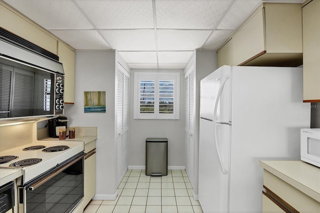 6480 Midnight Pass Rd Unit 311, Sarasota, FL 34242 - kitchen featuring cream cabinets, white appliances, light countertops, a paneled ceiling, and light tile patterned floors