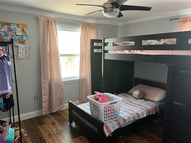 bedroom featuring ornamental molding, dark wood finished floors, baseboards, and a ceiling fan