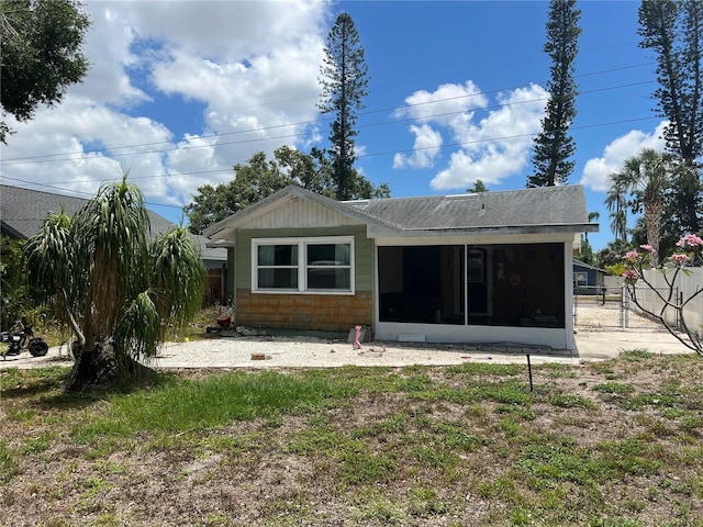 rear view of house with a sunroom and fence