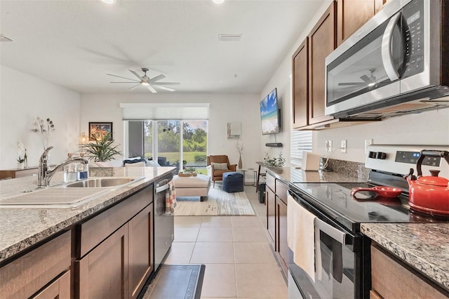 8628 Milestone Dr, Sarasota, FL 34238 - kitchen with stainless steel appliances, a sink, a ceiling fan, open floor plan, and light tile patterned floors