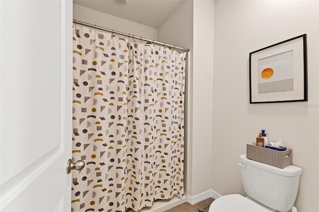 8628 Milestone Dr, Sarasota, FL 34238 - bathroom featuring toilet, a shower with curtain, and baseboards