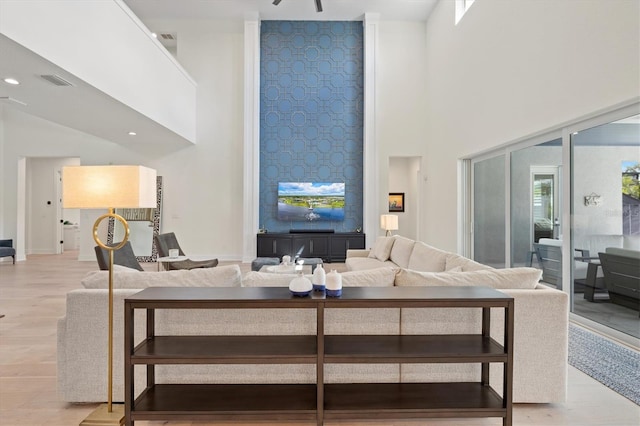 living area with a high ceiling and light wood finished floors