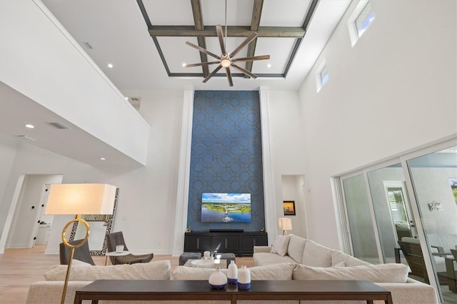 living area featuring a towering ceiling, coffered ceiling, a ceiling fan, wood finished floors, and recessed lighting