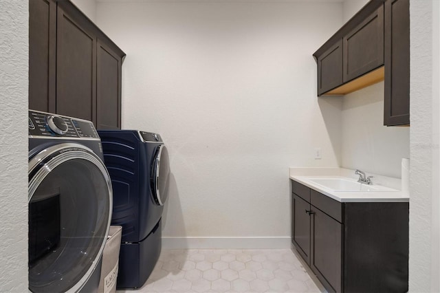 clothes washing area featuring cabinet space, washing machine and dryer, and baseboards