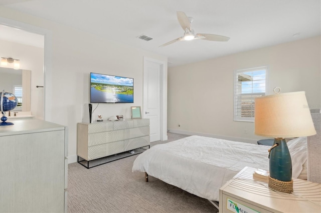 bedroom with light colored carpet, a ceiling fan, and baseboards