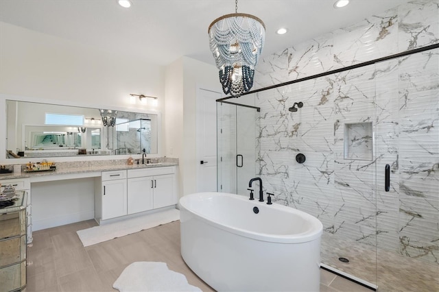 full bathroom featuring a chandelier, a shower stall, vanity, a freestanding bath, and recessed lighting