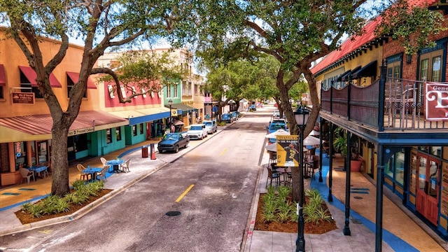 view of asphalt road with sidewalks, curbs, and street lights
