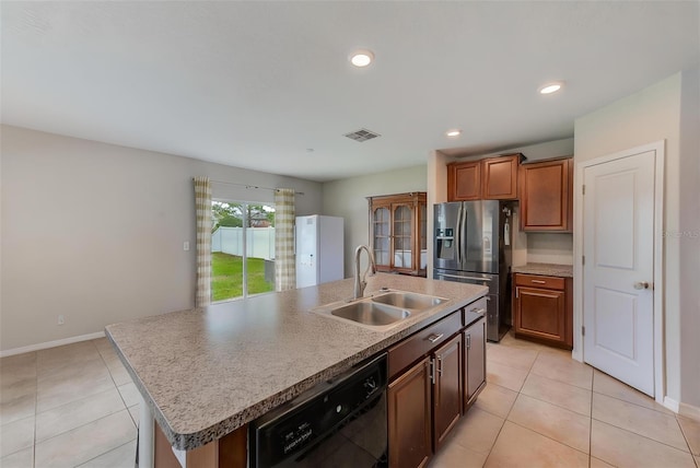 10944 Rainbow Pyrite Dr, Wimauma, FL 33598 - kitchen featuring black dishwasher, a sink, stainless steel fridge, an island with sink, and light tile patterned floors