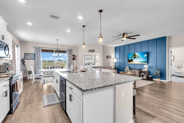 16411 62nd Gln E, Parrish, FL 34219 - kitchen with stainless steel appliances, a sink, open floor plan, light wood-style flooring, and recessed lighting
