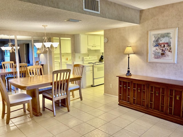 6124 43rd St W Unit 104A, Bradenton, FL 34210 - dining space featuring a chandelier, light tile patterned floors, and a textured ceiling