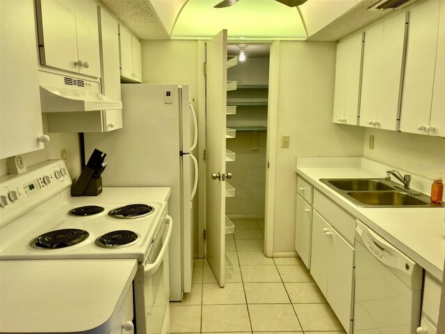 6124 43rd St W Unit 104A, Bradenton, FL 34210 - kitchen featuring white appliances, under cabinet range hood, a sink, light tile patterned floors, and light countertops