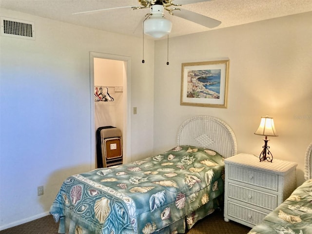 6124 43rd St W Unit 104A, Bradenton, FL 34210 - bedroom featuring dark carpet, baseboards, a closet, ceiling fan, and a spacious closet
