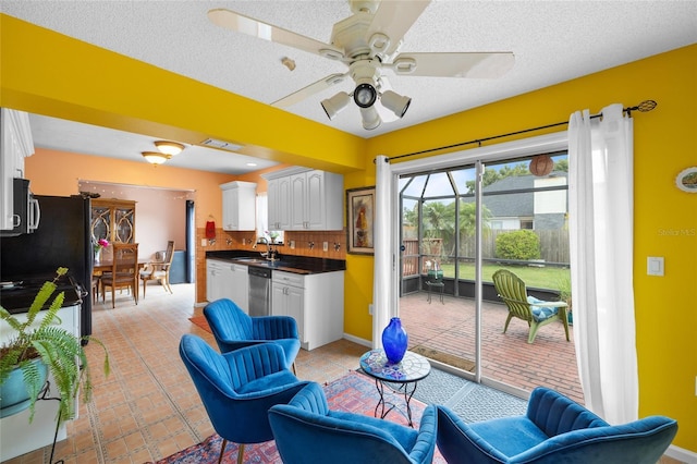 3910 77th Pl E, Sarasota, FL 34243 - kitchen with white cabinetry, dark countertops, a ceiling fan, stainless steel appliances, and tasteful backsplash