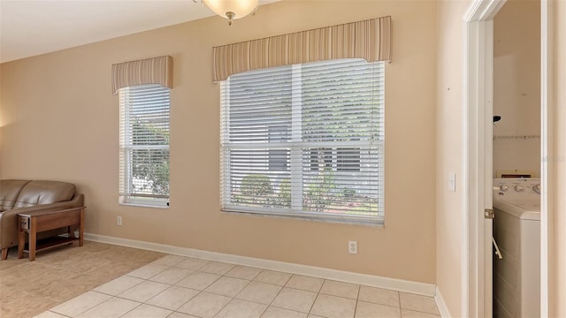 4274 Tennyson Way, Venice, FL 34293 - living area featuring washer / dryer, light tile patterned floors, plenty of natural light, and baseboards