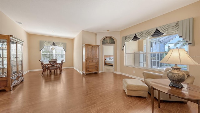 4274 Tennyson Way, Venice, FL 34293 - living area with a chandelier, wood finished floors, and baseboards