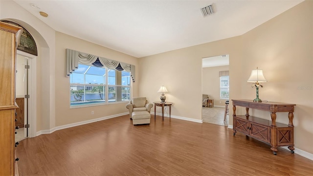 4274 Tennyson Way, Venice, FL 34293 - sitting room featuring healthy amount of natural light, wood finished floors, arched walkways, and baseboards