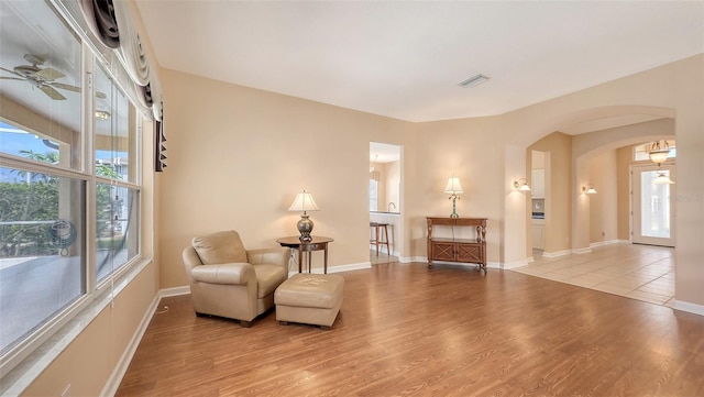 4274 Tennyson Way, Venice, FL 34293 - living area featuring arched walkways, wood finished floors, ceiling fan, and baseboards