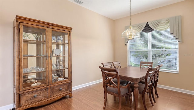 4274 Tennyson Way, Venice, FL 34293 - dining area featuring a chandelier, baseboards, and light wood-style flooring