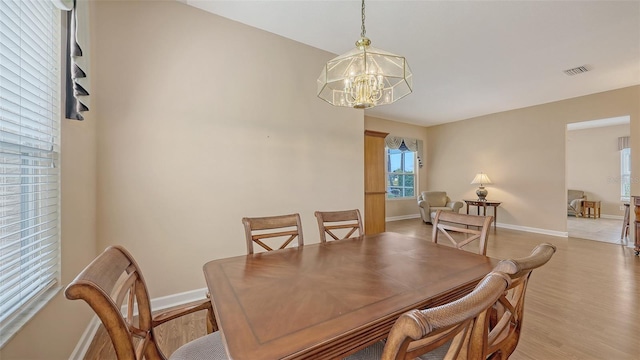 4274 Tennyson Way, Venice, FL 34293 - dining area with a chandelier, baseboards, and light wood-style flooring