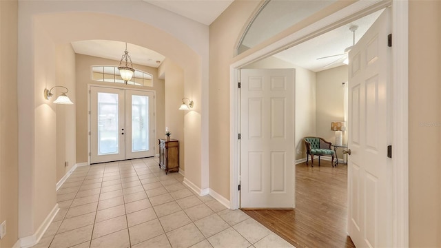 4274 Tennyson Way, Venice, FL 34293 - entrance foyer with arched walkways, baseboards, french doors, and light wood-style floors