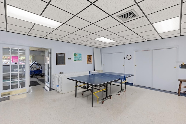 recreation room with speckled floor and a drop ceiling