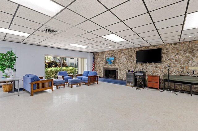 living area featuring a paneled ceiling and a fireplace
