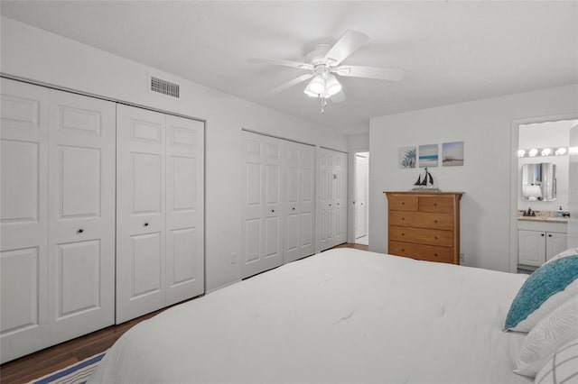 5681 Midnight Pass Rd Unit 104, Sarasota, FL 34242 - bedroom with two closets, dark wood-style floors, ensuite bath, and ceiling fan