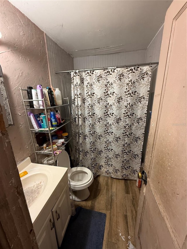 1113 23rd Ave W, Bradenton, FL 34205 - bathroom with wood finished floors, toilet, vanity, curtained shower, and a textured wall