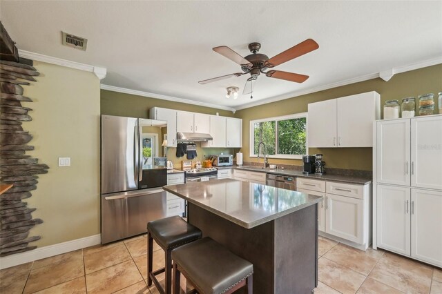 4468 Maraldo Ave, North Port, FL 34287 - kitchen featuring appliances with stainless steel finishes, under cabinet range hood, a sink, crown molding, and white cabinetry