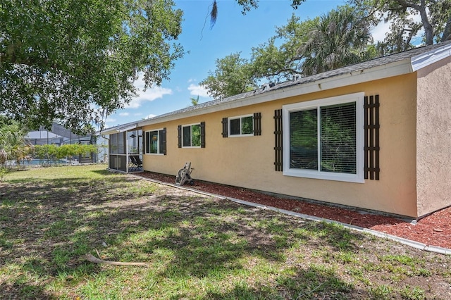 4468 Maraldo Ave, North Port, FL 34287 - view of property exterior featuring stucco siding, a lawn, and a sunroom