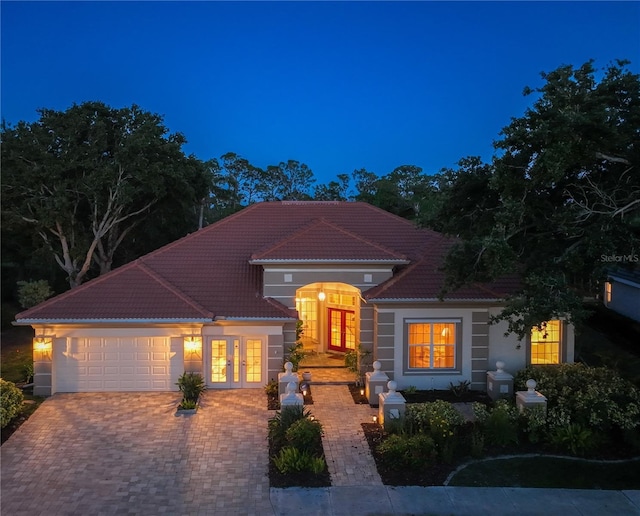 766 Shadow Bay Way, Osprey, FL 34229 - mediterranean / spanish-style house featuring french doors, a tiled roof, a garage, and decorative driveway