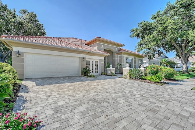 766 Shadow Bay Way, Osprey, FL 34229 - mediterranean / spanish-style house featuring french doors, an attached garage, stucco siding, and a tiled roof