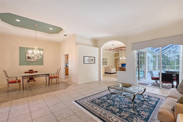 766 Shadow Bay Way, Osprey, FL 34229 - living room with a chandelier, crown molding, light tile patterned floors, a raised ceiling, and arched walkways