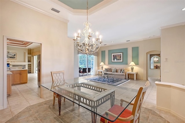 766 Shadow Bay Way, Osprey, FL 34229 - dining area with ornamental molding, arched walkways, a chandelier, light tile patterned flooring, and a tray ceiling
