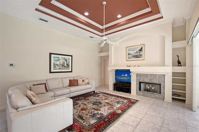 766 Shadow Bay Way, Osprey, FL 34229 - living area with ornamental molding, a tray ceiling, a tiled fireplace, ceiling fan, and built in features