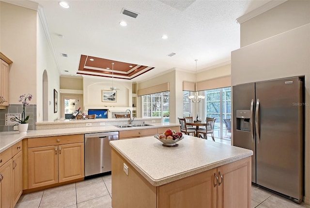 766 Shadow Bay Way, Osprey, FL 34229 - kitchen featuring appliances with stainless steel finishes, light brown cabinetry, a peninsula, ornamental molding, and light tile patterned floors
