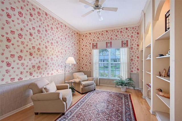 766 Shadow Bay Way, Osprey, FL 34229 - living area with wallpapered walls, light wood finished floors, crown molding, a ceiling fan, and wainscoting