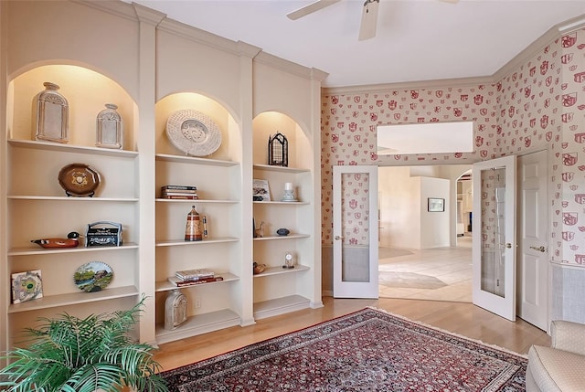 766 Shadow Bay Way, Osprey, FL 34229 - hallway featuring french doors, light wood-type flooring, built in shelves, wallpapered walls, and crown molding