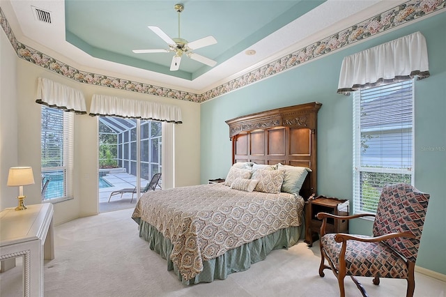 766 Shadow Bay Way, Osprey, FL 34229 - bedroom featuring access to outside, light carpet, a ceiling fan, and a tray ceiling