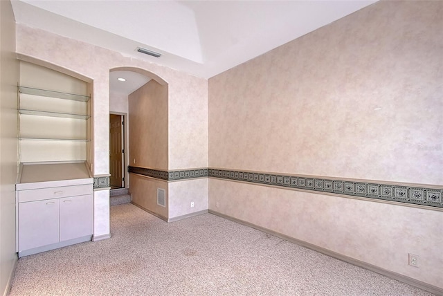 766 Shadow Bay Way, Osprey, FL 34229 - empty room with arched walkways and light carpet