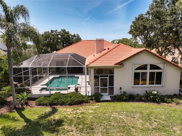 766 Shadow Bay Way, Osprey, FL 34229 - rear view of house with a tiled roof, a chimney, a patio area, stucco siding, and a lawn