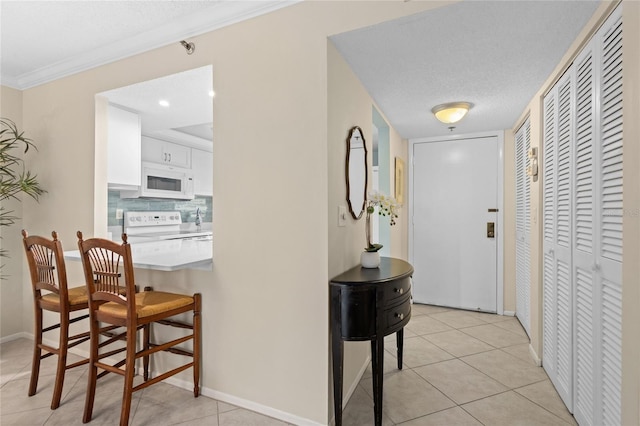 1001 Benjamin Franklin Dr Unit 106, Sarasota, FL 34236 - hall with light tile patterned floors, baseboards, ornamental molding, and a textured ceiling