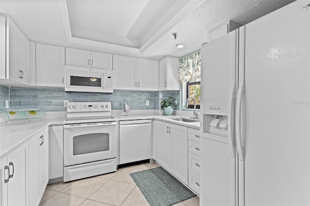 1001 Benjamin Franklin Dr Unit 106, Sarasota, FL 34236 - kitchen featuring white appliances, a sink, white cabinets, and backsplash